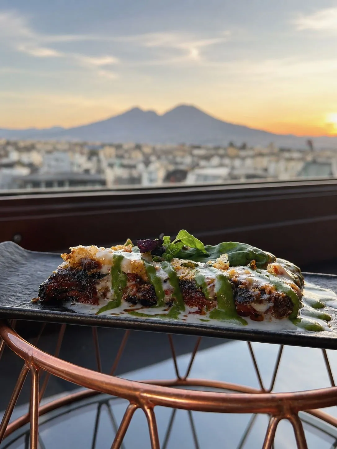 Un piatto in terrazza con vista su Napoli e il Vesuvio