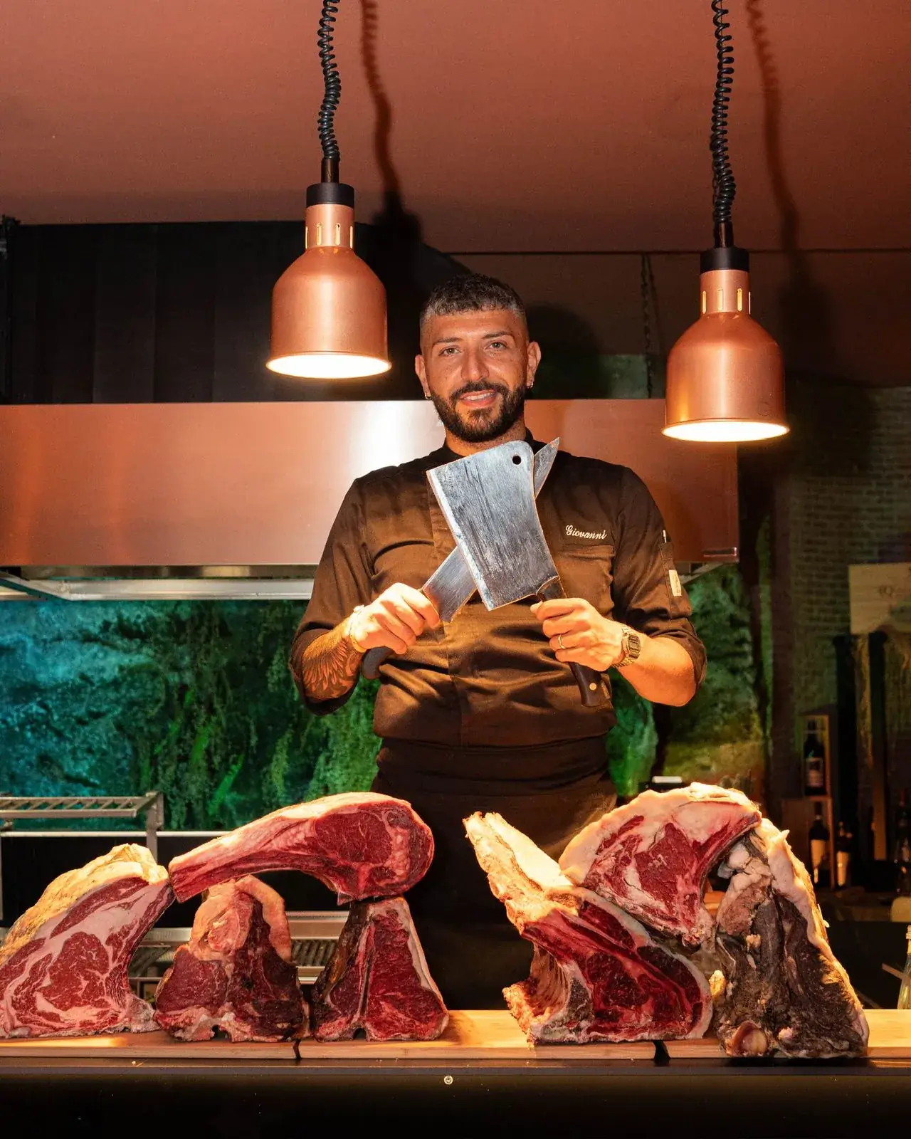 Il macellaio con la mannaia dietro ai tagli di manzo
